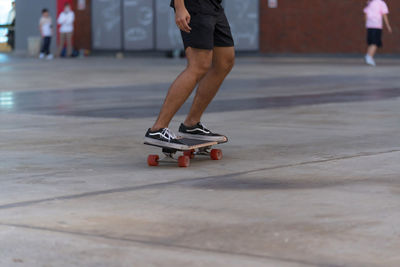 Low section of man skateboarding on street