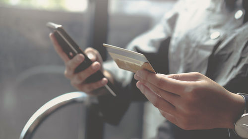 Midsection of man using mobile phone