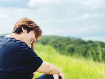 Side view of woman on field against sky