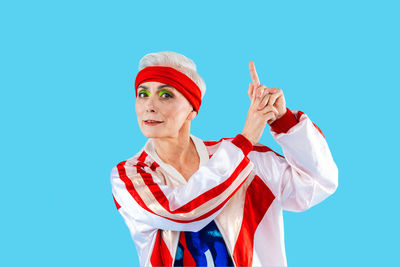 Portrait of woman holding gift against blue background