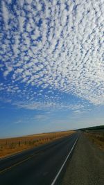 Empty road passing through field