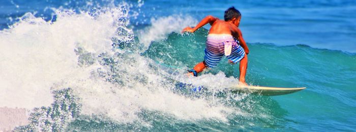 Rear view of man surfing in sea