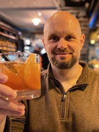 Portrait of a smiling man with drink in restaurant