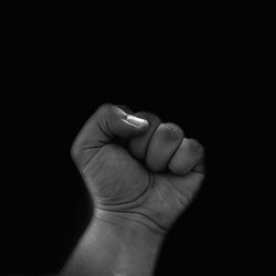 Close-up of human hand against black background