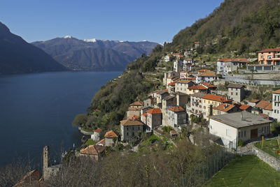 Town by sea and mountains against sky