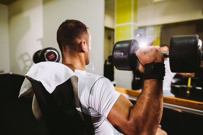 Man lifting dumbbells in gym