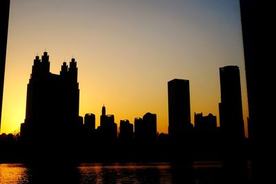 Silhouette buildings against clear sky during sunset