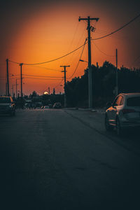 Cars on road against sky during sunset