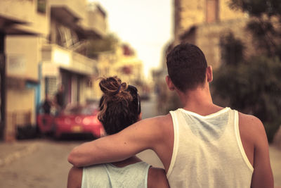 Rear view of couple against buildings