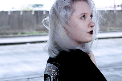 Young woman with dyed hair looking away