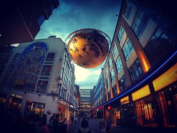 Low angle view of people in city against sky