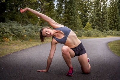 Full length of woman sitting on road