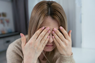 Pretty brunette woman covering her face with both hands. person