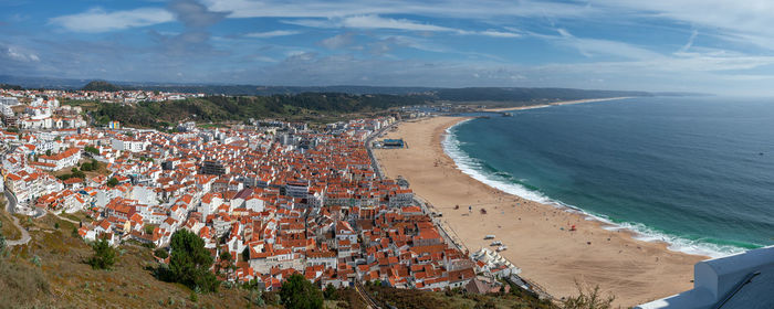 High angle view of townscape by sea against sky