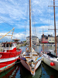 Sailboats moored at harbor