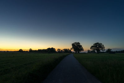 Scenic view of field against clear sky during sunset