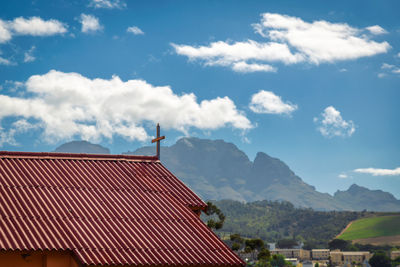 Roof of building and mountains against sky