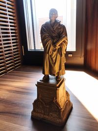 Statue of buddha against window