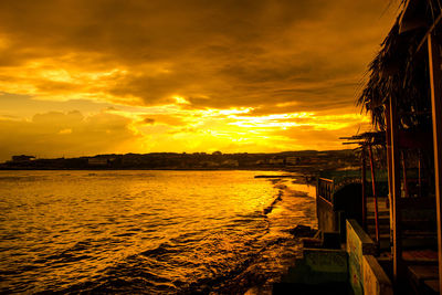 Scenic view of sea against dramatic sky during sunset
