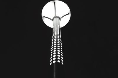 Low angle view of illuminated lamp against black background