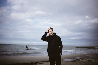 Full length of man standing on beach against sky