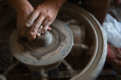 Cropped image of craftsperson working on pottery wheel