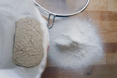 Overhead view of flour and sieve on table