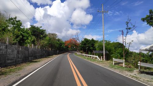 Road amidst trees against sky