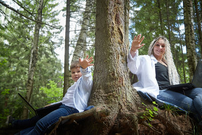 Side view of woman sitting in forest