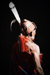 Rear view of woman standing against black background