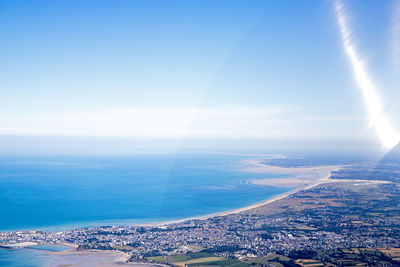 Aerial view of city by sea against sky