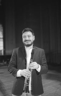 Man holding clarinet while standing at studio