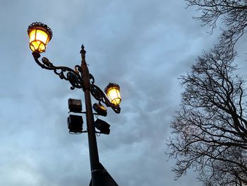 Low angle view of illuminated street light against sky