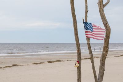 Flag on beach against sky