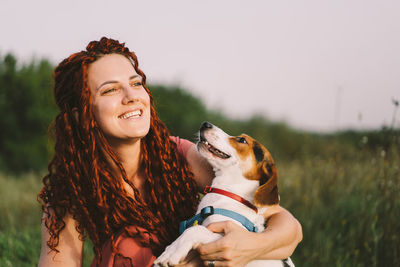 Beautiful woman plays with her jack russell dog in the park.