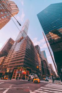 Low angle view of skyscrapers against cloudy sky