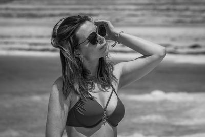 Woman wearing sunglasses while standing on beach