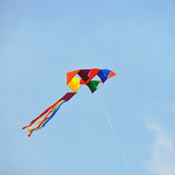 Low angle view of colorful balloons against blue sky