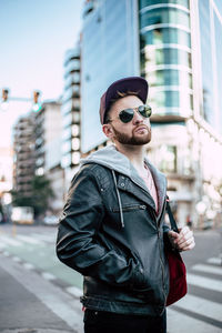 Portrait of man wearing sunglasses standing in city