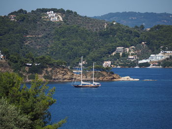 Sailboat sailing on sea by mountain