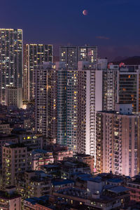 Illuminated buildings in city against sky at night