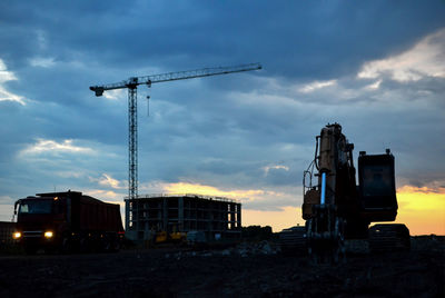 Cranes at construction site against sky