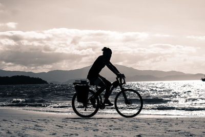 Man riding bicycle on beach