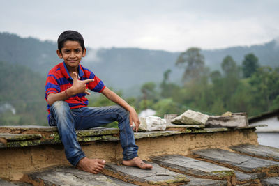 Portrait of boy sitting on mountain