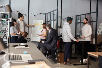 Creative businessman giving presentation during meeting in office