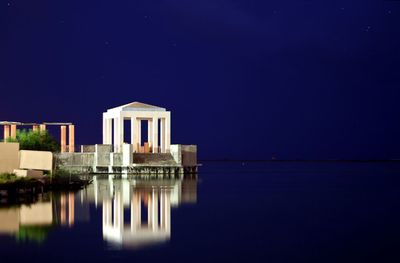 Reflection of building in lake at night
