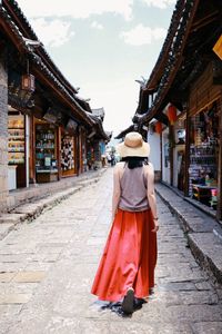 Rear view of woman walking in temple against building