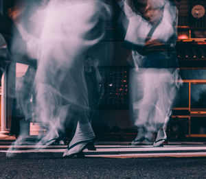 Low section of people walking on road in city