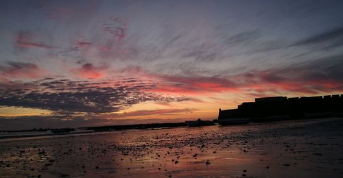 Scenic view of beach against sky during sunset