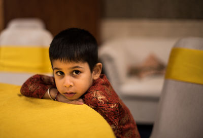 Portrait of young woman sitting on bed at home